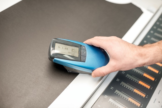 A person is measuring the black intensity using a spectrometer machine